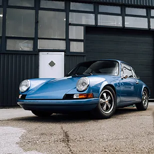 Photographie d'une Porsche 911 devant un bâtiment industriel
